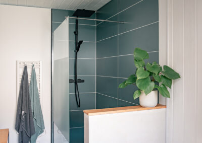 Rénovation d’une salle de bain à Loupian, Bassin de Thau près de Montpellier, avec douche à l’italienne, carrelage vert d'eau et finitions bois.